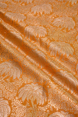 Textured fabric with a palm tree pattern in orange and beige.