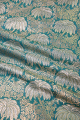 Textile with silver palm tree pattern on a teal background