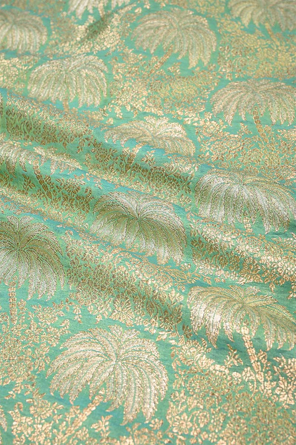 Gold palm leaf pattern on a teal background
