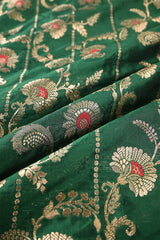 Close-up of green fabric with gold floral embroidery