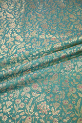 Close-up of Sea green fabric with gold zari and meenakari floral jaal pattern