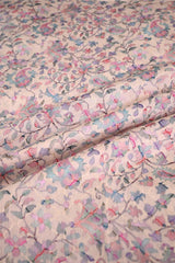 Close-up of Floral patterned fabric with pink, blue, and green colors on a light background