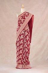 Close up of maroon Georgette Khaddi Silk Saree showing gold zari floral jaal and handcrafted lace border.