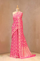 Close up of Pink Banarasi Georgette Khaddi Silk Saree showing gold zari floral jaal on the body and reverse scalloped border.