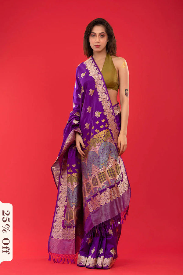 Woman wearing a purple saree with gold patterns on a red background