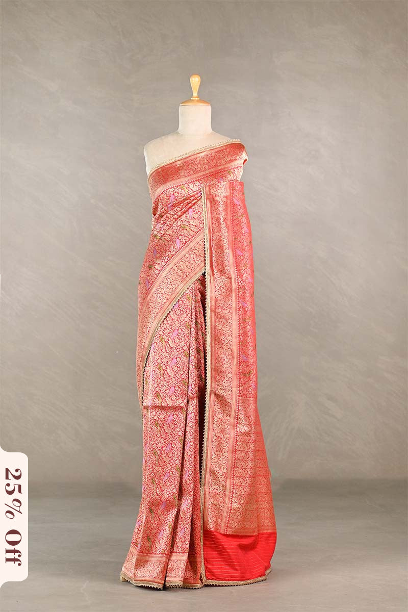 Red saree with gold patterns on a mannequin against a neutral background