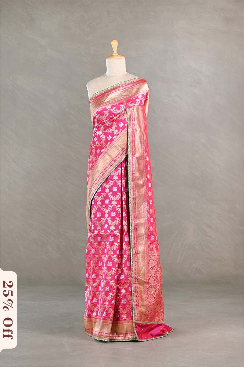 Pink saree with a floral pattern on a mannequin against a gray background