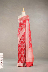 Red Banarasi silk saree with light gold floral woven patterns draped on a mannequin against a gray background