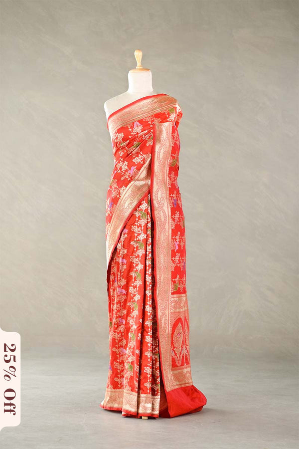 Red Banarasi silk saree with floral patterns on a mannequin against a plain background