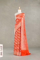 Orange silk saree with gold zari floral patterns on a mannequin against a gray background