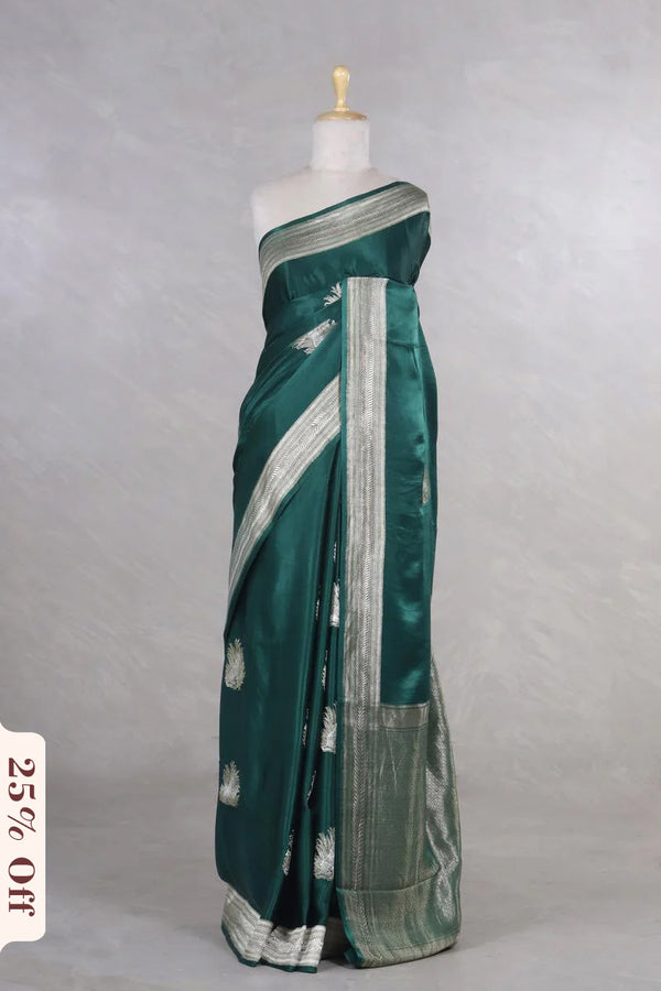Green saree with silver border on a mannequin against a gray background