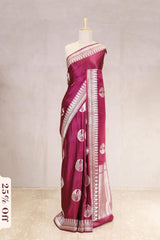 Magenta saree with white patterns on a mannequin against a light gray background