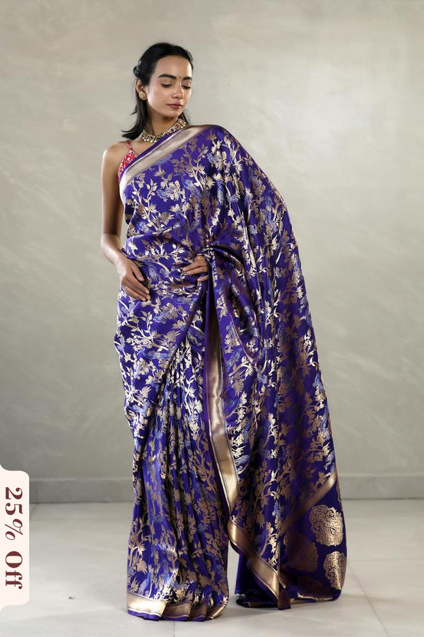 Woman wearing a blue floral saree with a plain background