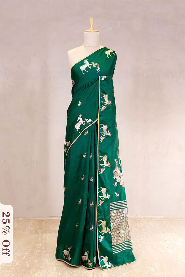 Green saree with white patterns on a mannequin against a plain background