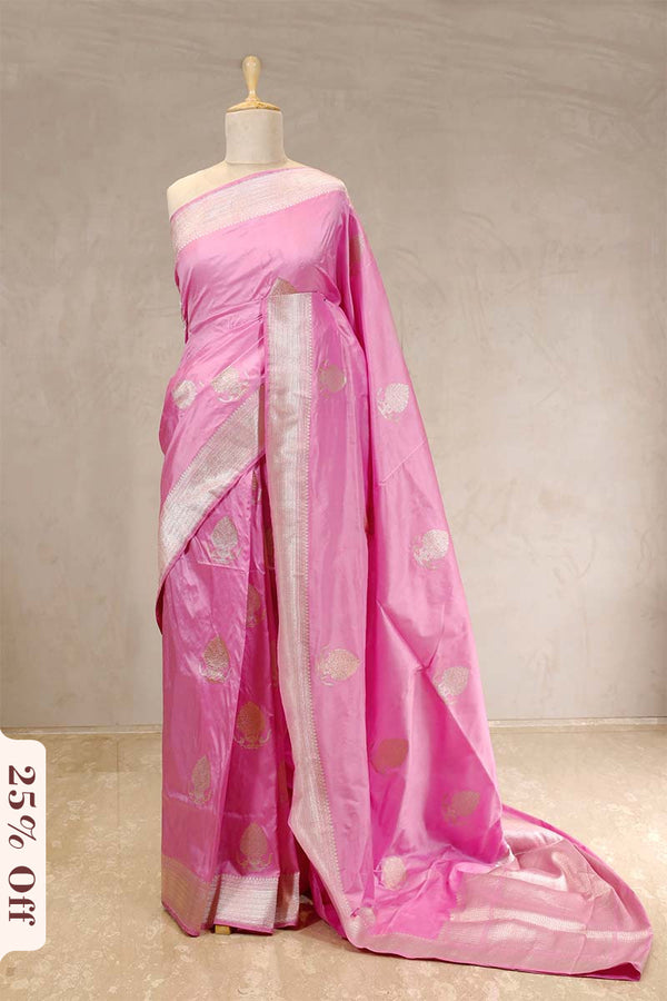 Pink saree with white blouse on a mannequin against a plain background