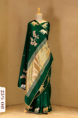 Green saree with elephant patterns on a mannequin against a beige background