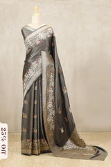 Gray saree with floral patterns on a mannequin against a neutral background