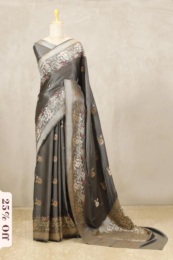 Gray saree with floral patterns on a mannequin against a neutral background