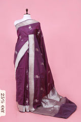 Purple saree with white border on a mannequin against a pink background