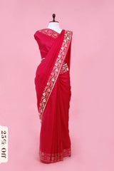 Red saree with gold embroidery on a pink background