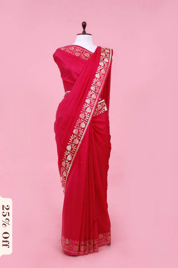 Red saree with gold embroidery on a pink background