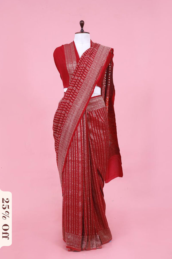 Red saree with white patterns on a pink background