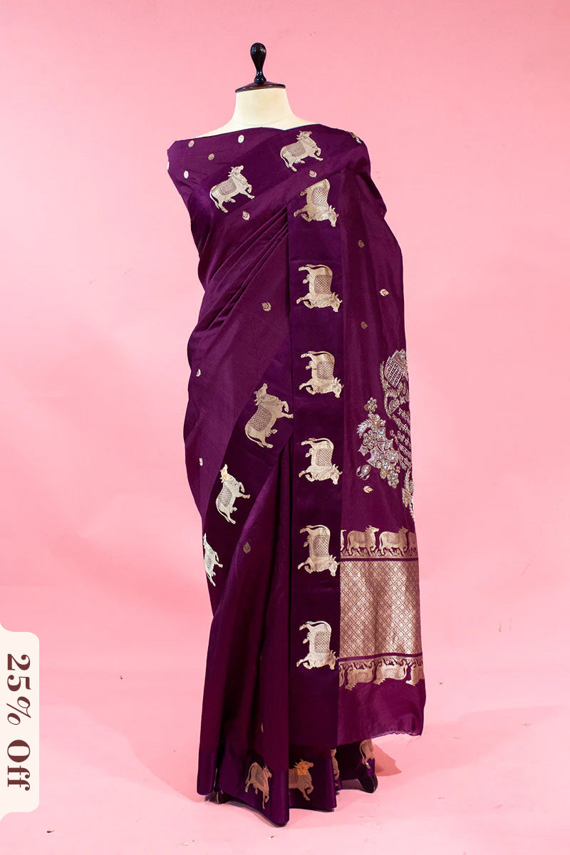 Purple saree with elephant patterns on a mannequin against a pink background