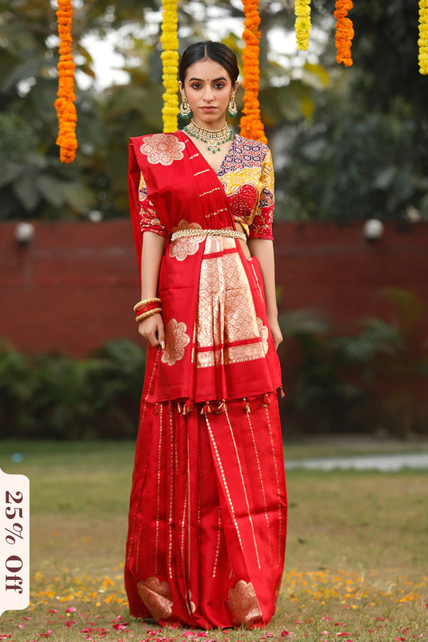 Woman in a red traditional outfit with gold details standing outdoors.