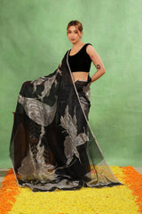Women wearing Black Organza Silk Saree showing half and half design with silver stripes and flora fauna applique work.