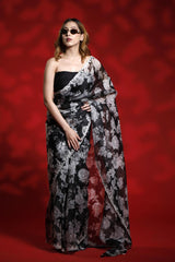 Woman wearing a floral party wear saree dress for a cocktail party looks against a red background