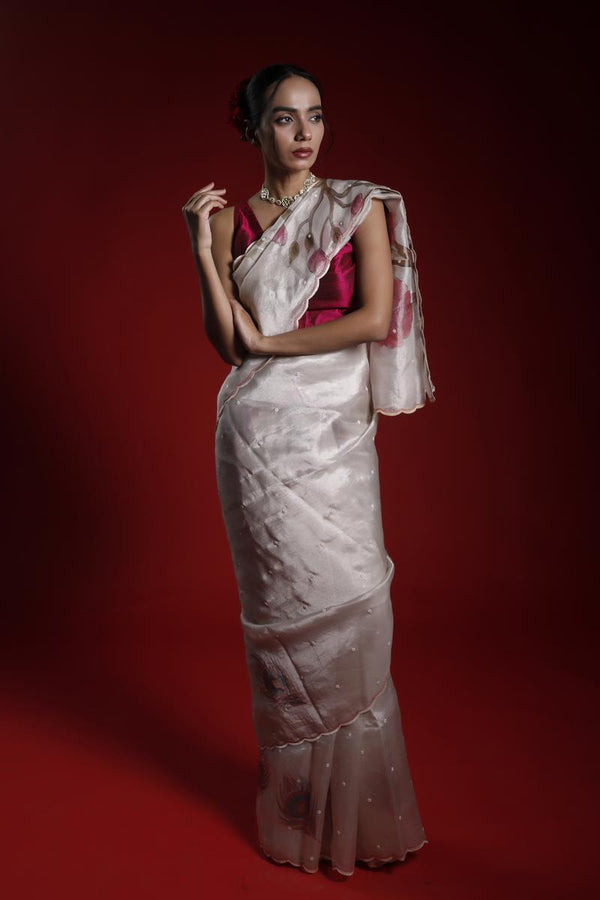 A woman wearing a party wear saree with a red and white floral pattern on a red background