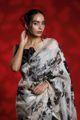 Woman wearing a floral party wear white saree dress for a cocktail party looks against a red background