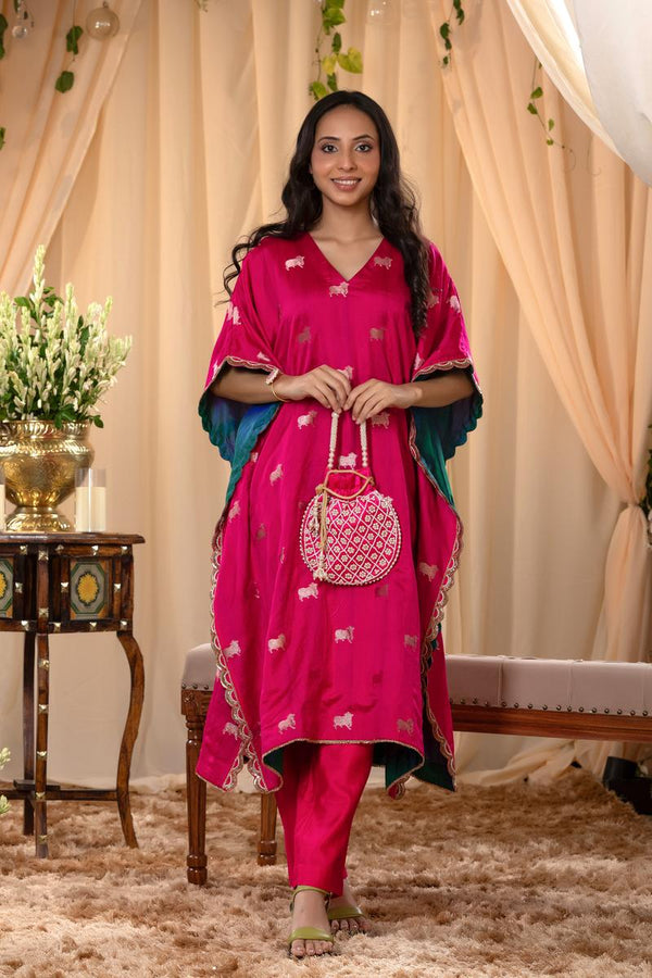 A woman in a pink traditional kaftan co-ord set, standing in a decorated indoor setting.