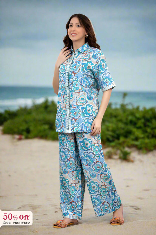 Woman wearing a floral outfit on a beach with ocean view