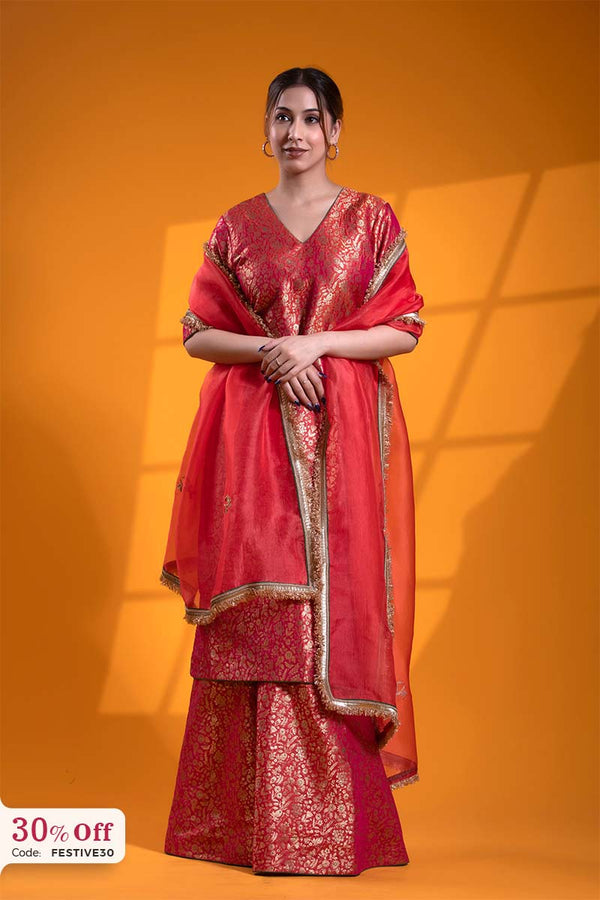 Woman wearing a red traditional outfit with gold details against an orange background