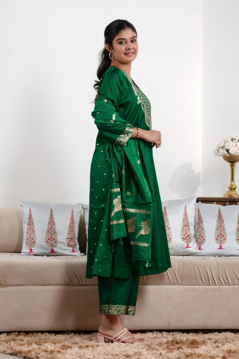 Woman in a green traditional outfit standing in a living room.
