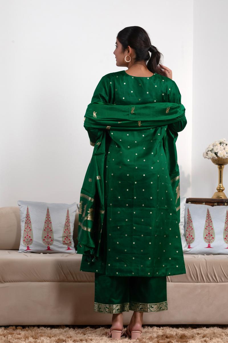 Woman in a green traditional outfit standing in a living room.