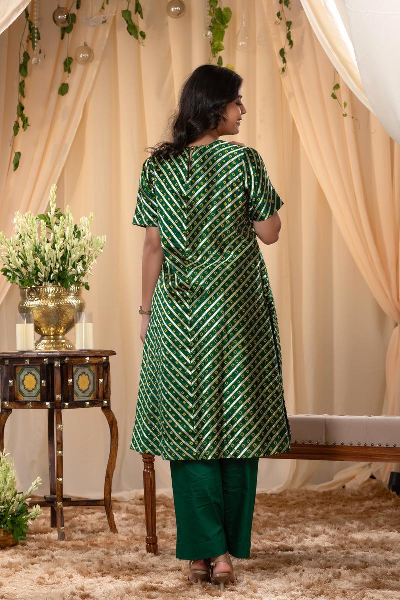A woman in a green traditional kurti co-ord set, standing in a decorated indoor setting.