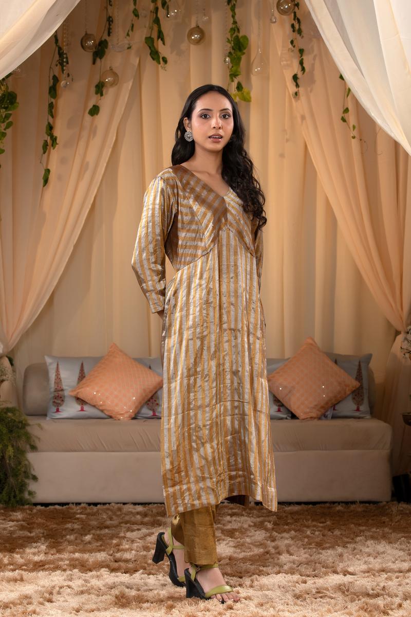 A woman in a traditional Kurti made with golden Tissue Silk Fabric for party wear looks like Deepika Padukone