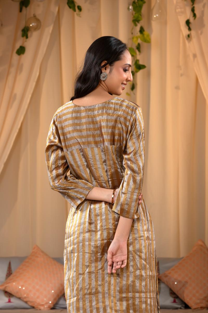A woman in a traditional Kurti made with golden Tissue Silk Fabric for party wear looks like Deepika Padukone