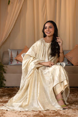A woman in a traditional off white salwar suit and off white banarasi dupatta 