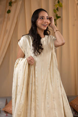 A woman in a traditional off white salwar suit and off white banarasi dupatta 