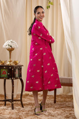 A woman in a pink Indo-Western dress, paired with a matching coat featuring pichwai motifs.