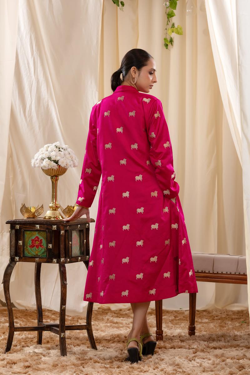 A woman in a pink Indo-Western dress, paired with a matching coat featuring pichwai motifs.