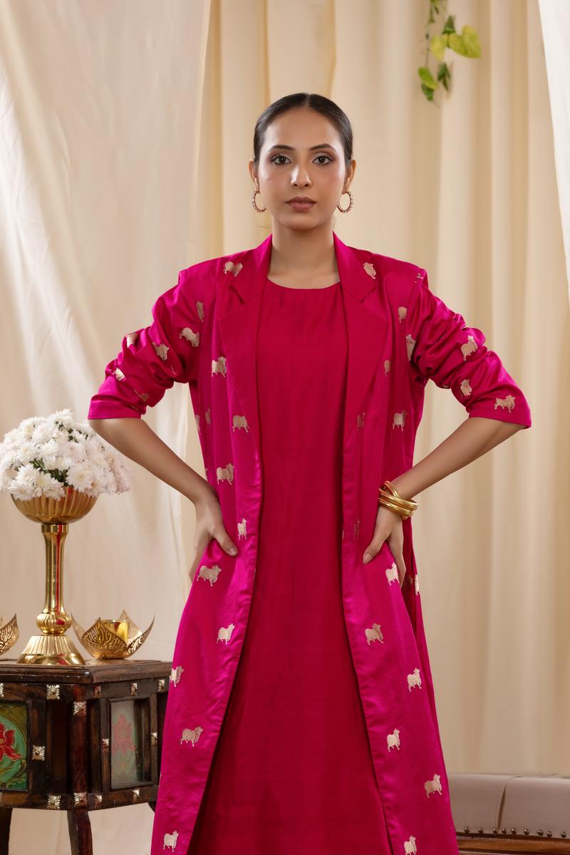 A woman in a pink Indo-Western dress, paired with a matching coat featuring pichwai motifs.