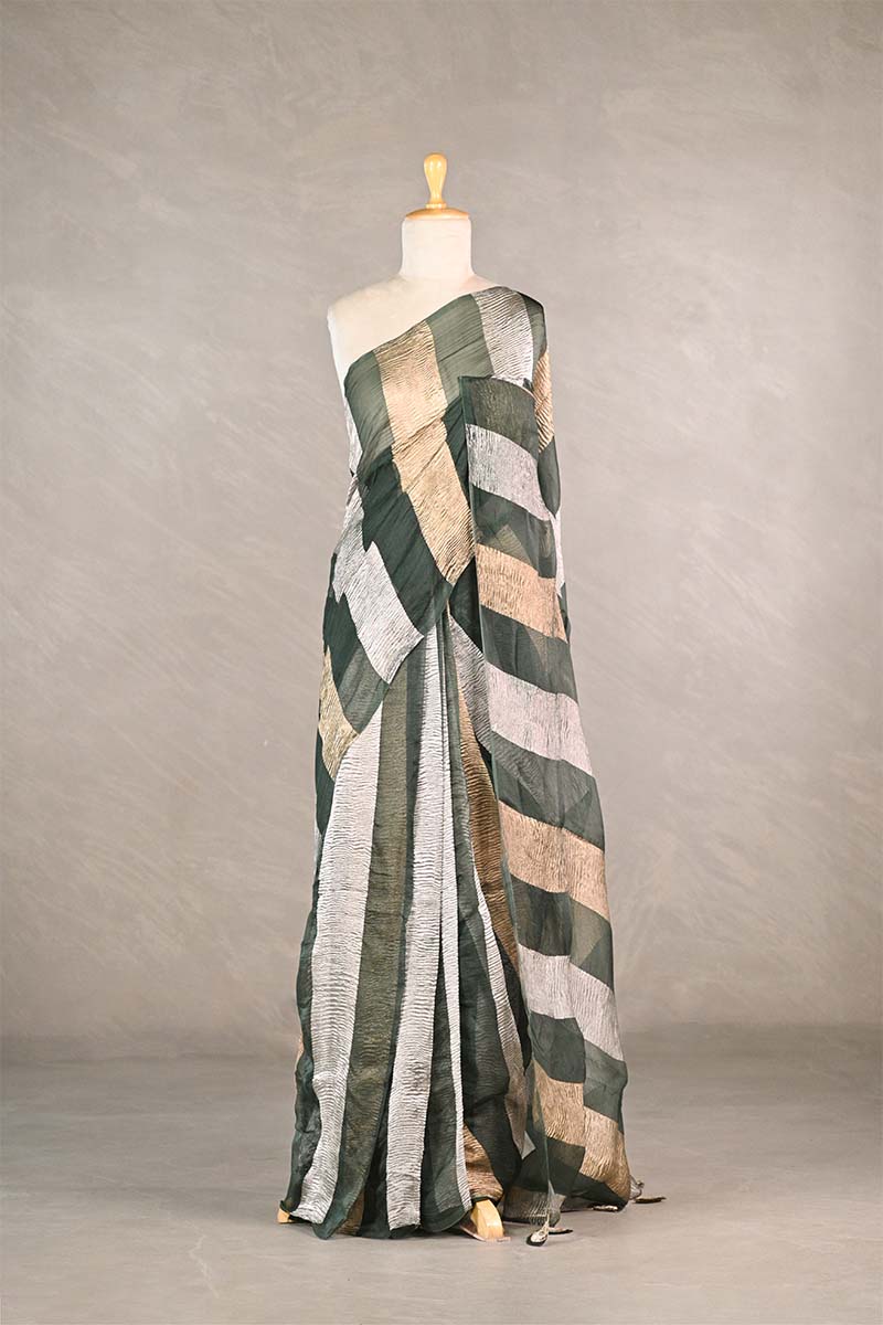 Sage Green gold and silver checkered organza silk tissue saree draped on a mannequin against a gray background