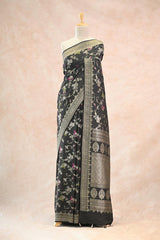 Black saree with floral patterns on a mannequin against a beige background