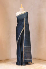 Charcoal Grey saree with white border on a mannequin against a beige background
