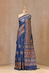 Close up of Blue Tussar Silk Saree showing Ajrakh printed buta highlighted with pitta zari work on the body and matching unstitched embellished blouse.