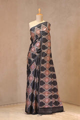 Close up of Black Tussar Silk Saree showing digital Ajrakh prints highlighted with hand-done aari embroidery and pitta zari embellishments.